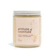 Candle jar labeled 'Attitude of Gratitude' on a white background
