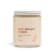 Candle jar with 'Rest, Reflect, Renew' text on a white background